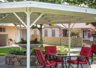 A covered patio outside in the gardens of Kingsburg Care Center
